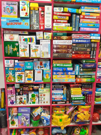 Full rack of board games including chess, ludo, business and puzzle sets