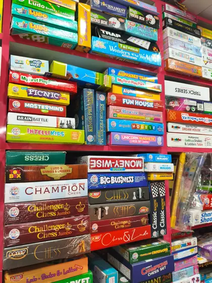 Chess, ludo and family board games stacked on shelves