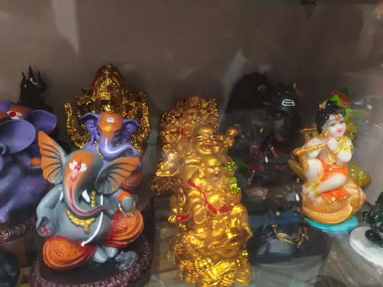 Decorative Ganesh and laughing Buddha statues in gold finish