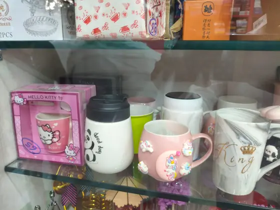 Gift mugs and packed gift boxes on a glass shelf