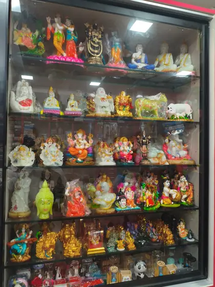Tall showcase of god idols and brass-finish statues