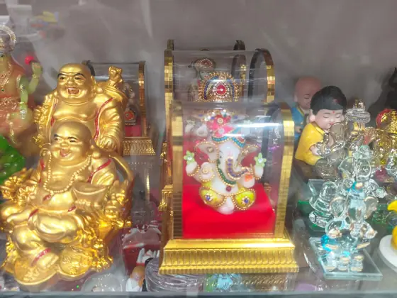Laughing Buddha statue and a framed Ganesh piece