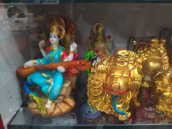 Saraswati idol and brass-finish Buddha figures